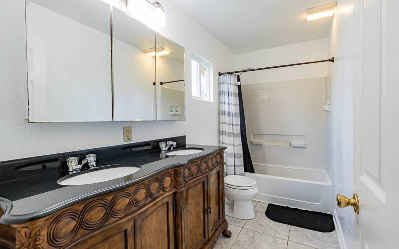 bathroom with double sinks and medium dark wood vanity