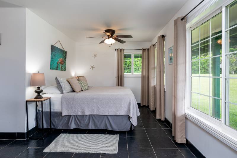 small bedroom with large windows on north shore of oahu