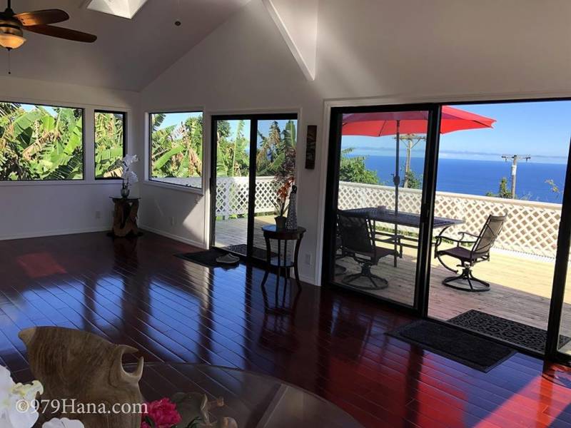 living room with wall of windows to ocean view lanai