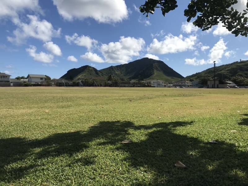 grassy park in kalama valley oahu with fluffy white clouds in the sky