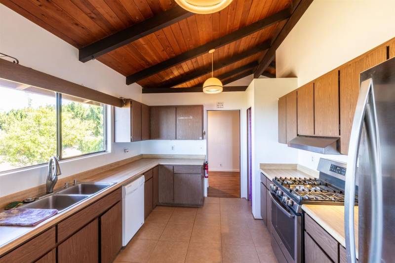 kitchen in kula maui home wit wood cabinets and tile floors