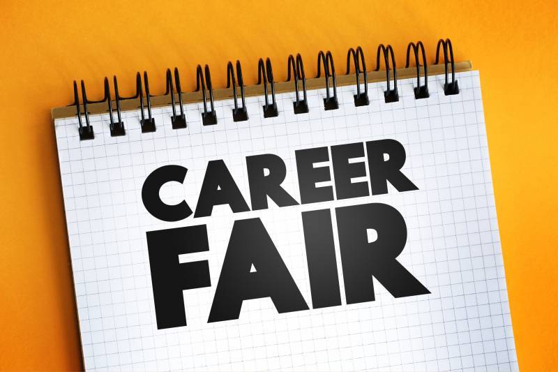 notepad with text that reads career fair on top of a yellow background