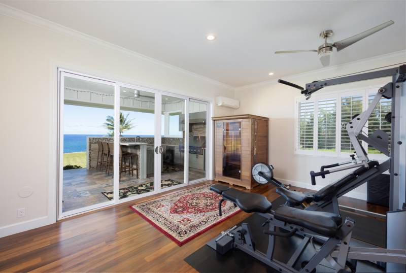 home gym space with sliding glass door to lanai with ocean views