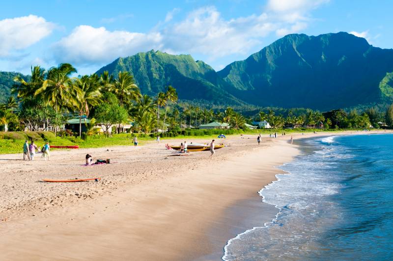 people enjoy a sunny day at the beach in hanalei on kauai north shore