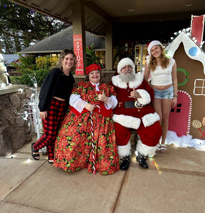 two women pose with santa and mrs claus