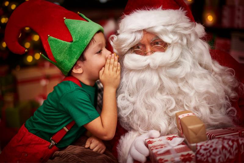 elf whispering to santa claus