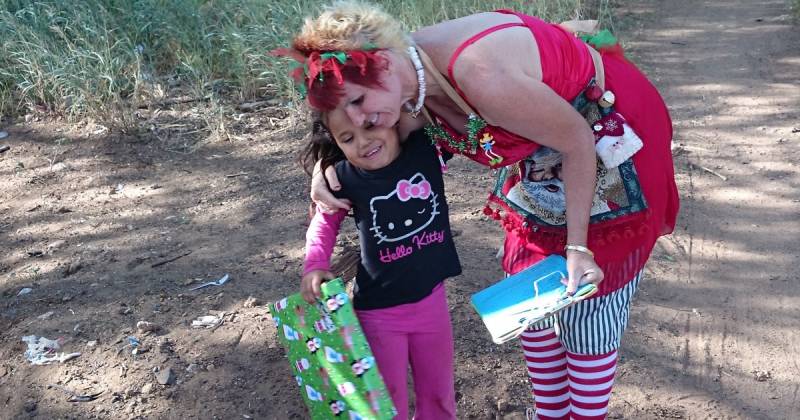 woman gives girl christmas gift for charity