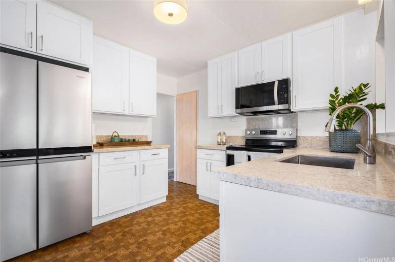 kitchen includes stainless steel appliances and white cabinets