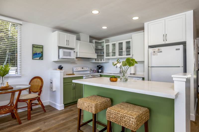 modern condo kitchen with green lower cabinets and white uppers