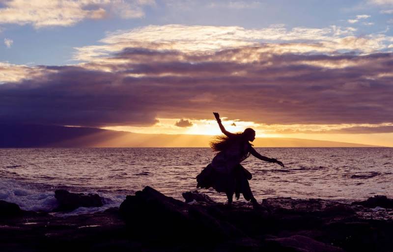 hula dancer by the ocean at sunset