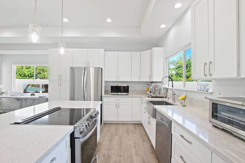 modern kitchen featuring white cabinets, white countertops, and stainless steel appliances