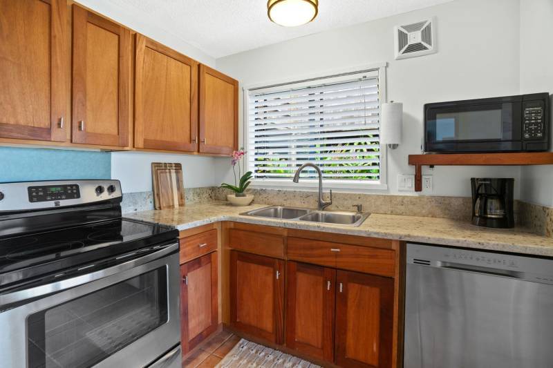 kauai condo kitchen with warm wood cabinets and granite countertops