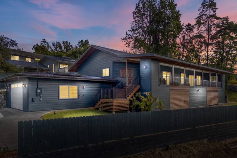 exterior big island house for sale with warms lights on at dusk