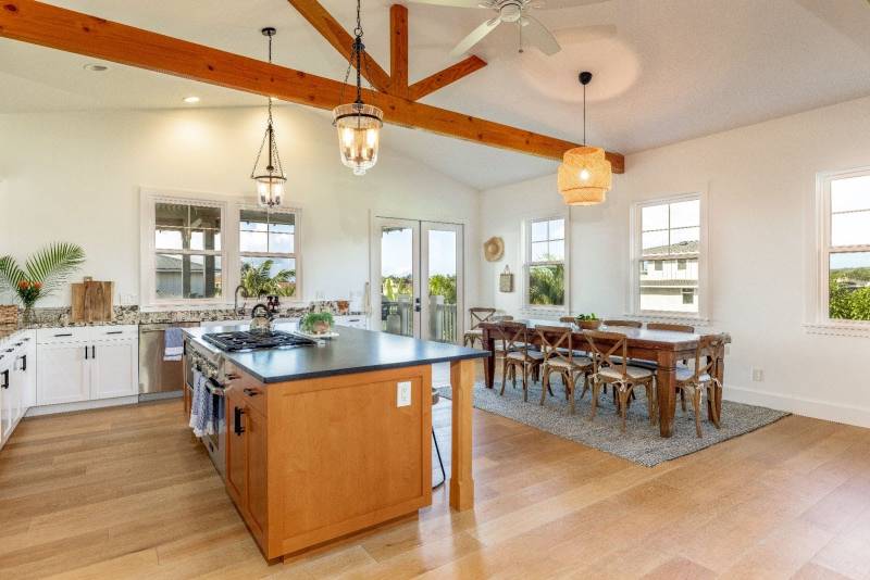 open kitchen and dining area with wood beams on ceiling