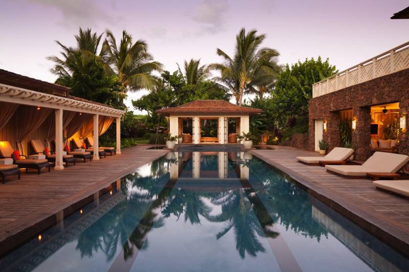 rectangular pool lined with lounge chairs at the spa at kukuiula club