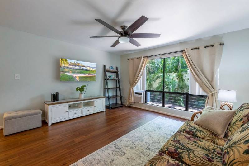 living room in maui condo with wood floors and glass to doors to the lanai