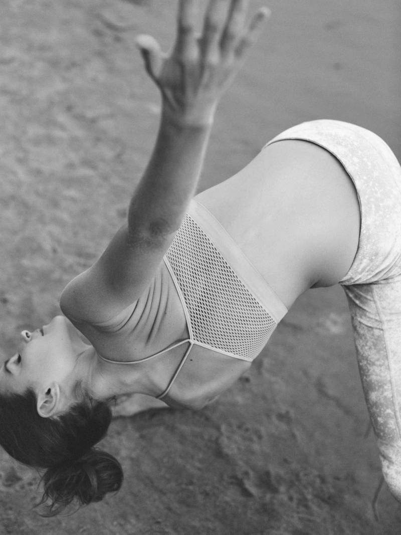 black and white photo of woman doing Yoga on beach