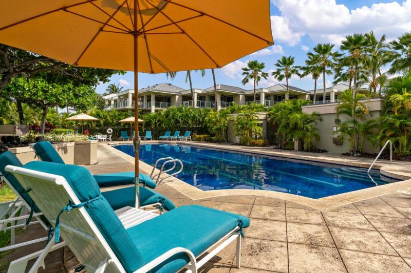 chairs on the deck of pool at waikoloa vista condo community