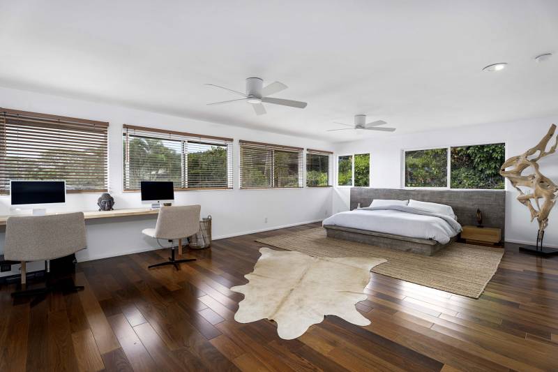 large bedroom with two computers on long desk