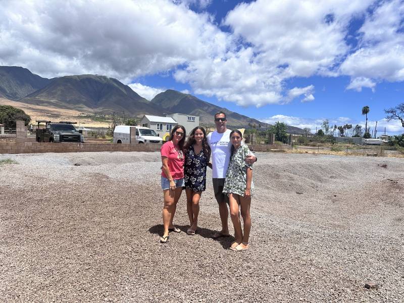 family stands on empty lot one year after Lahaina wildfire