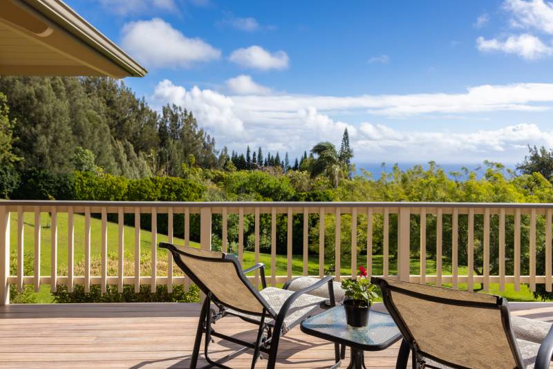 chairs on lanai looking out at green country ocean views in hawaii