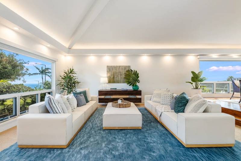 parallel white sofas on top of blue rug in sitting area in hawaii loa ridge home