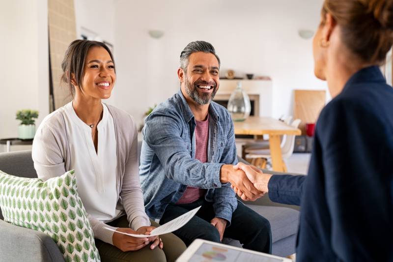 people shaking hands after signing real estate contract