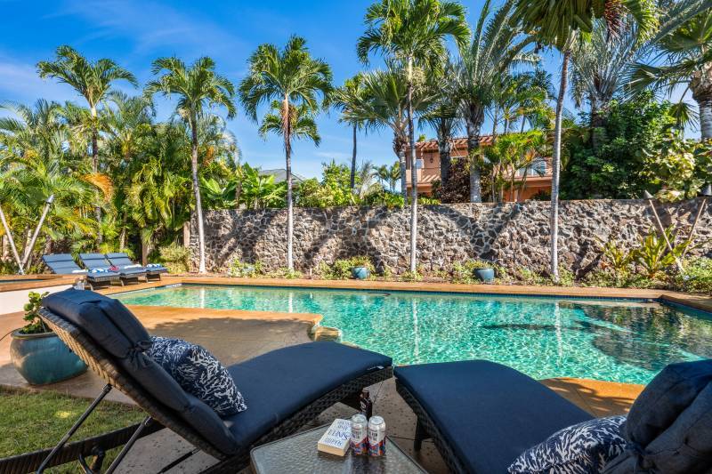 sparkling blue pool in front of lava rock wall in luxury lahaina home for sale