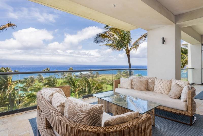 large covered lanai seating area overlooking the ocean at montage kapalua bay maui vacation rental