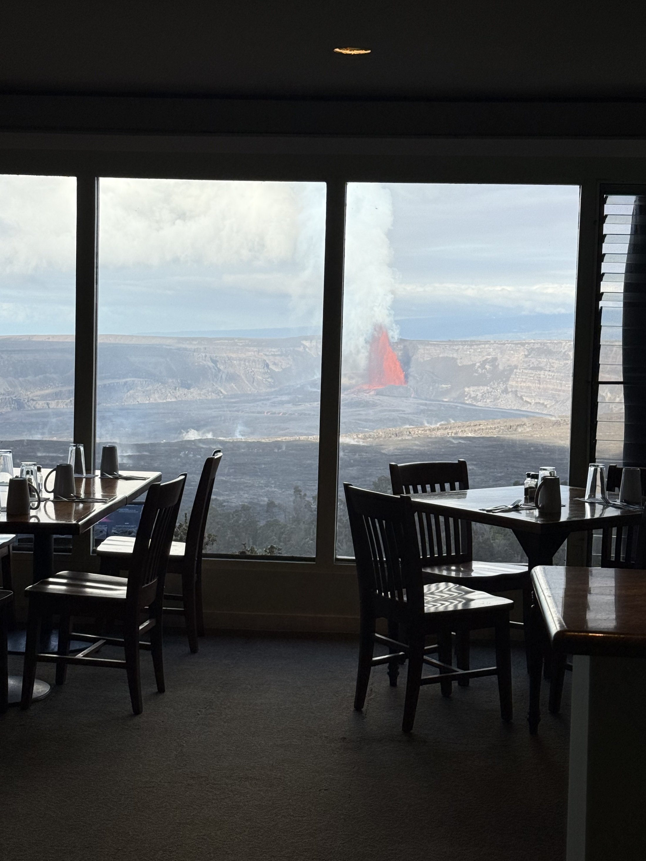 dining room with view of kilauea erupting through the windows