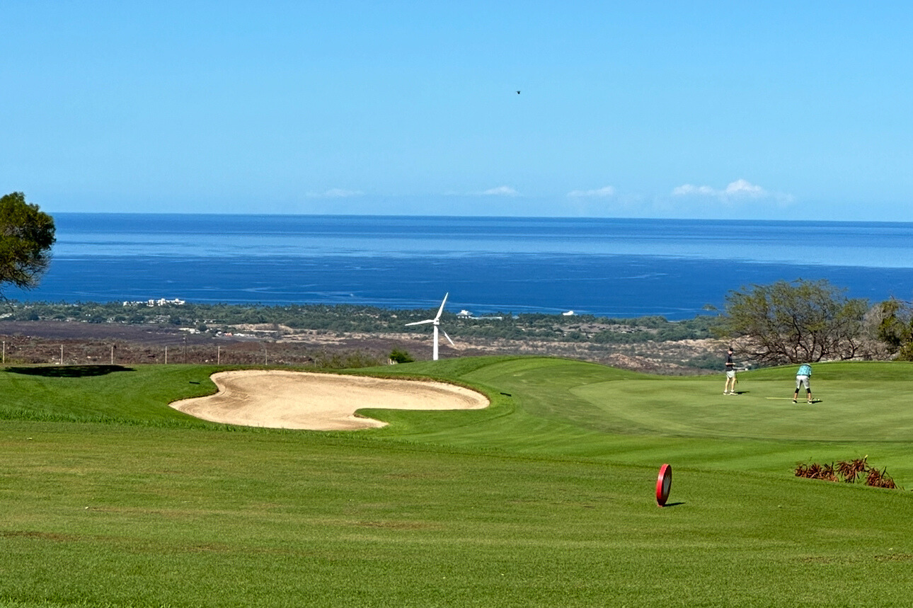 ハワイ島ワイコロアビレッジの斜面に広がるゴルフコースとオーシャンビュー。海を望む住宅やコンドミニアムが点在