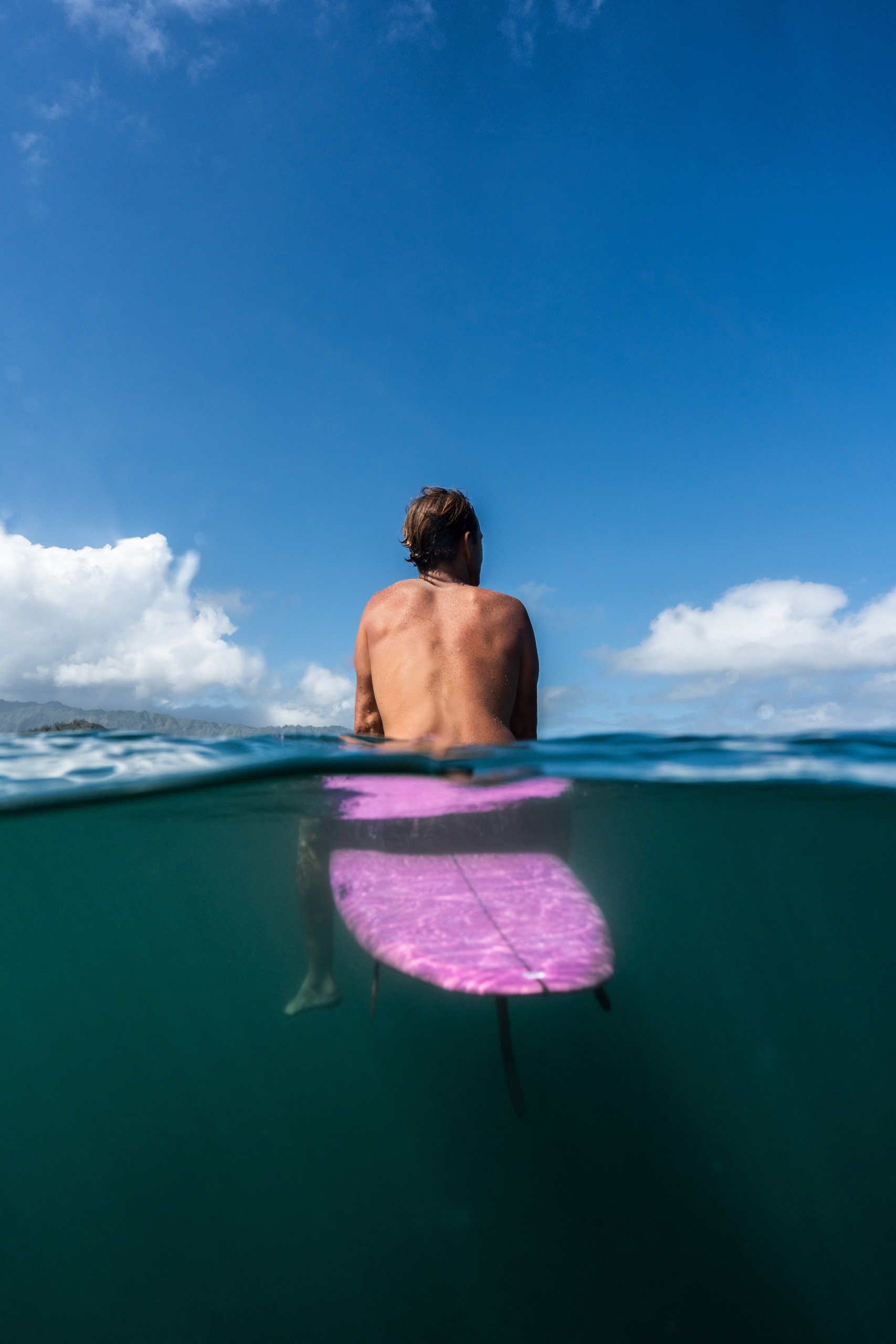 man sitting on surfboard in the ocean