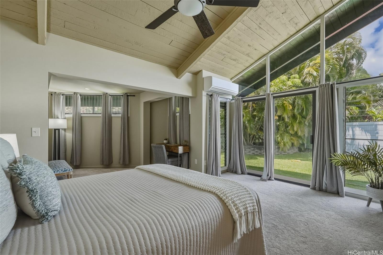 Spacious bedroom with large windows to let in Oahu tropical views