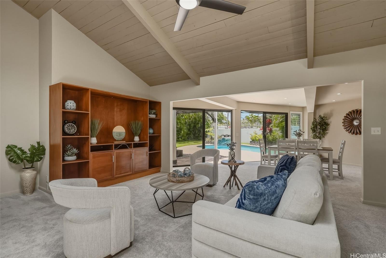 Living room in Portlock Oahu home with glass doors to backyard with pool