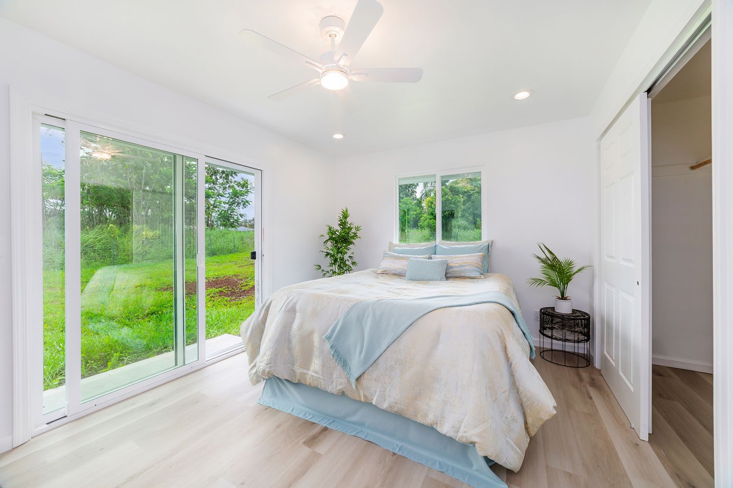 Bedroom with sliding doors to green backyard
