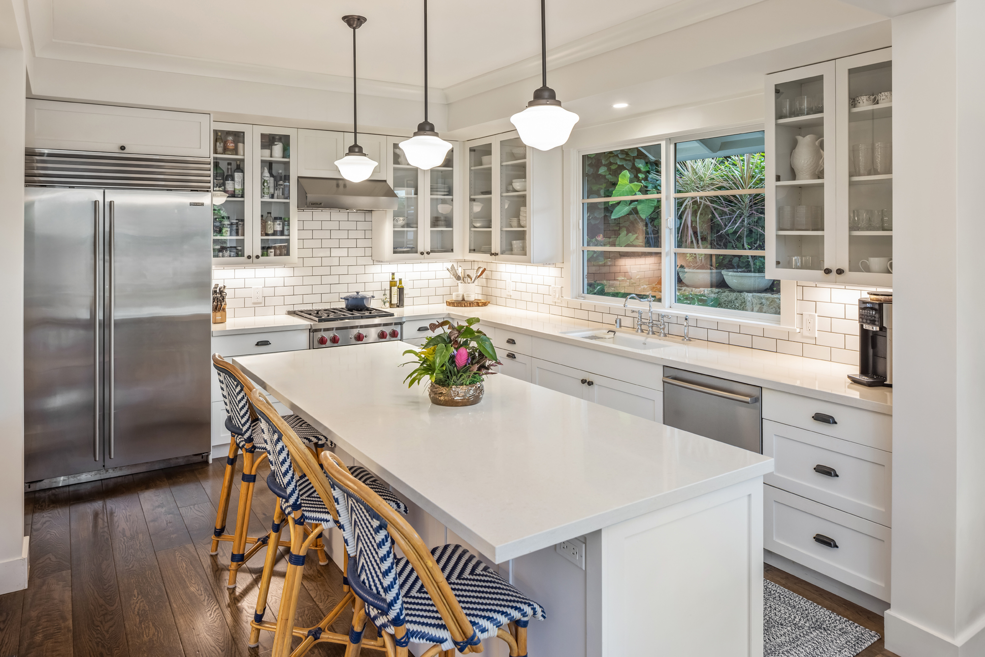 Kitchen outfitted with white cabinets and countertops and high end stainless steel appliances